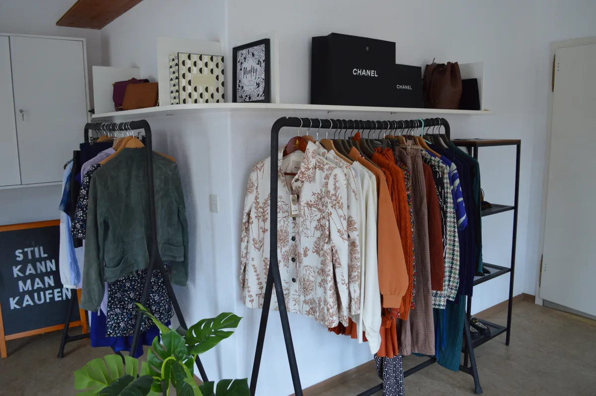 Zwei Kleiderstangen mit bunter Kleidung.